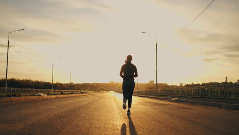 morning-jog-of-young-woman-sportswoman-is-running-along-on-road-in-outskirts-of-city